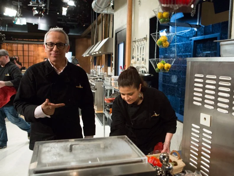 Chefs Alex Guarnaschelli and Geoffrey Zakarian joke around while they work with the ingredients from the "short order" episode: banana pudding, vanilla ice cream, icing, brownie mix, as seen on Food Network's Chopped After Hours, Season 21.