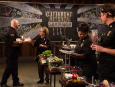 Chef Michael Psilakis hands over sabotage element, Salmon Swap, to chef Susan Feniger during Round 1 auction, as seen on Food Network's Cutthroat Kitchen, Season 5.