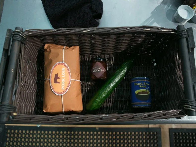 The mystery basket ingredients for the entree round are: pork loin, chocolate body paint, cucumbers and black bean soup, as seen on Food Network's Chopped, Season 21.