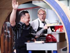 Guest Judge Jet Tila and Host Alton Brown in the Round 1 sabotage element, Hamster Wheel, as seen on Food Network's Cutthroat Kitchen, Season 11.