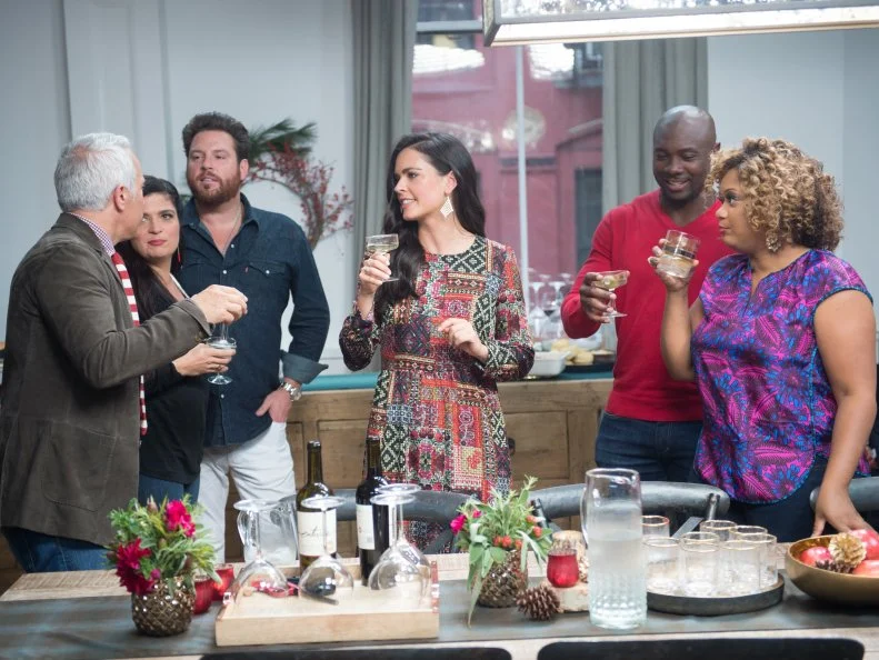 Host Bobby Flay and his guests Alex Guarneschelli, Anne Burrell, Katie Lee, Sunny Anderson, Eddie Jackson, Geoffrey Zacharian, and Scott Conant prepare dinner as seen on Food Network’s Bobby Flay’s Barbecue Addiction, Christmas at Bobby’s Special