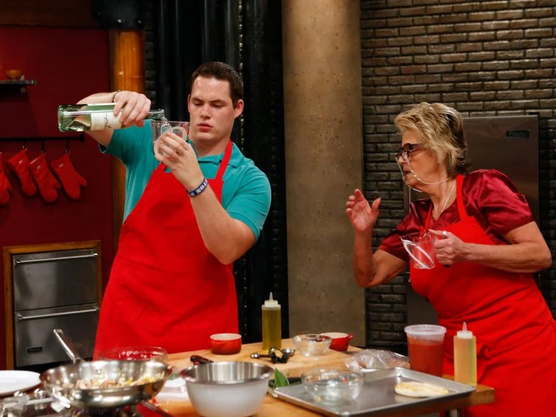 Red team recruits Taylor Hoopers and Donna Koen prepare host Anne Burrell's Chicken Cacciatore dish during a competition called "Family Food" as seen on Food Network's Worst Cooks in America, Season 8, Episode 2.