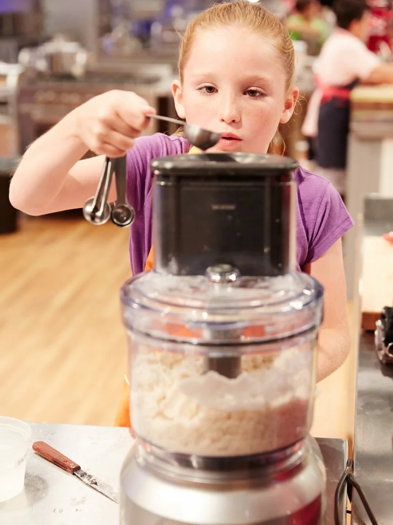 Baker Peggy Fischer preparing her dish, Lemon Meringue Pie with Chocolate Peanut Butter Candy Ice Cream, for the challenge, Pie A La Mode, as seen on Food Network’s Kids Baking Championship, Season 2.