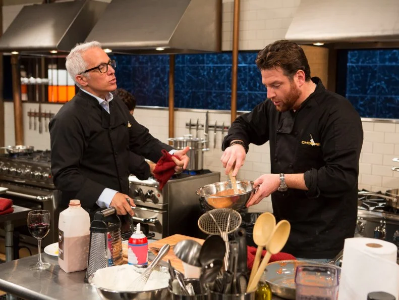 Chef Geoffrey Zakarian talks with chef Scott Conant while they both  work on their dishes that must include the late night foods:a rice and cheese burrito, chocolate milk, canned whipped cream and apple pies, as seen on Food Network's Chopped After Hours, Season 22.