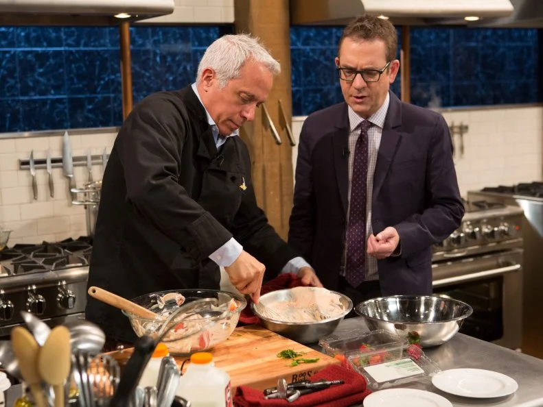 Chopped after hours host Ted Allen chats with Chef Geoffrey Zakarian while he works on his dish that must include: April fools day ingredients that are not what they seem. grilled cheese sandwiches = pound cake and frosting, tomato soup = strawberry puree, milk = buttermilk, peas and carrots = jelly beans, as seen on Food Network's chopped After Hours, season 23. as seen on Food Network's Chopped After Hours, Season 23.