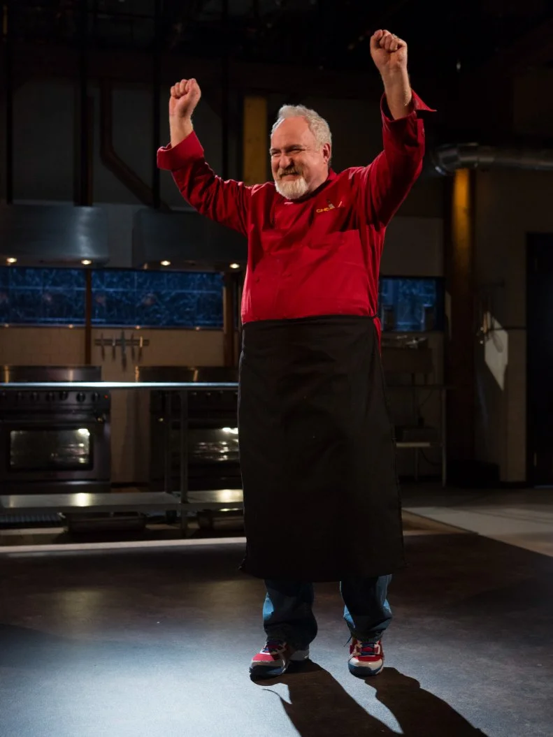 Chef Art Smith reacts to finding out he will move on to compete in the $75,000 charity competition finalfor Chopped $75,000 charity All-Stars competition, as seen on Food Network's Chopped, Season 24.