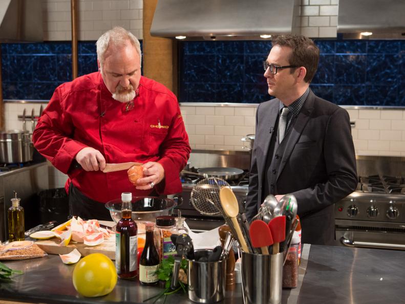 Chopped host Ted Allen checks in with chef Art Smith as he works on his entree that must include: shrimp skin, Hamachi, Pomelo and fresh green garlicfor Chopped $75,000 charity All-Stars competition, as seen on Food Network's Chopped, Season 24.