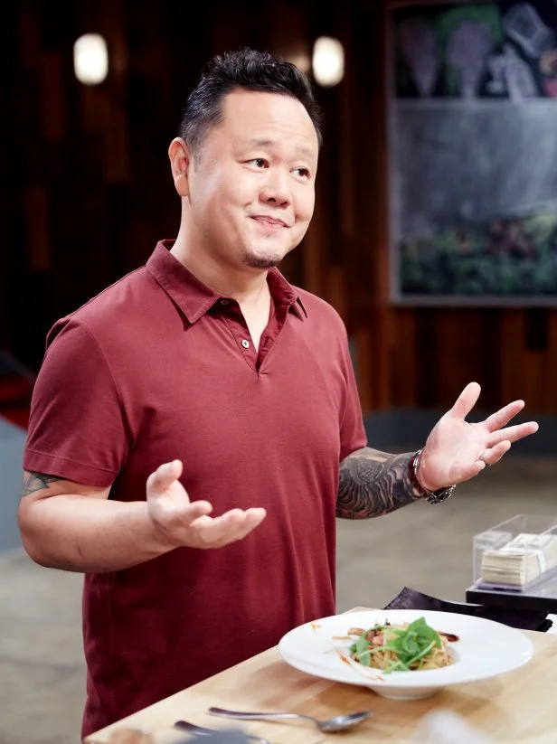 Host Jet Tila sample Chef Jason Febres' dish, "Shrimp and Bacon Stir Fry" for Round 1, as seen on Cutthroat Kitchen, Season 7.