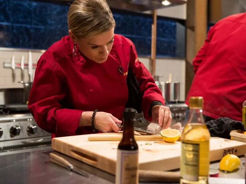 Chef Cat Cora works on her entree that must include:  lamb ribs, kumquats, white radicchio and spoon fruit for Chopped All-Stars $75,000 charity competition, as seen on Food Network's Chopped, Season 24.