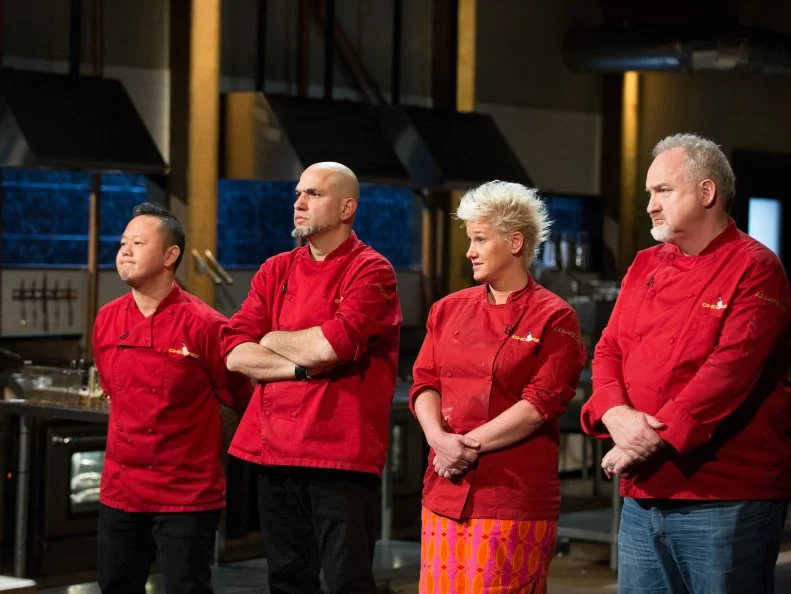 Competitor chefs, Jet Tila, Michael Psilakis, Anne Burrell and Art Smith stand before the judges, during the All Star Tournament Finale, as seen on Food Networkâ  s Chopped, Season 24.
