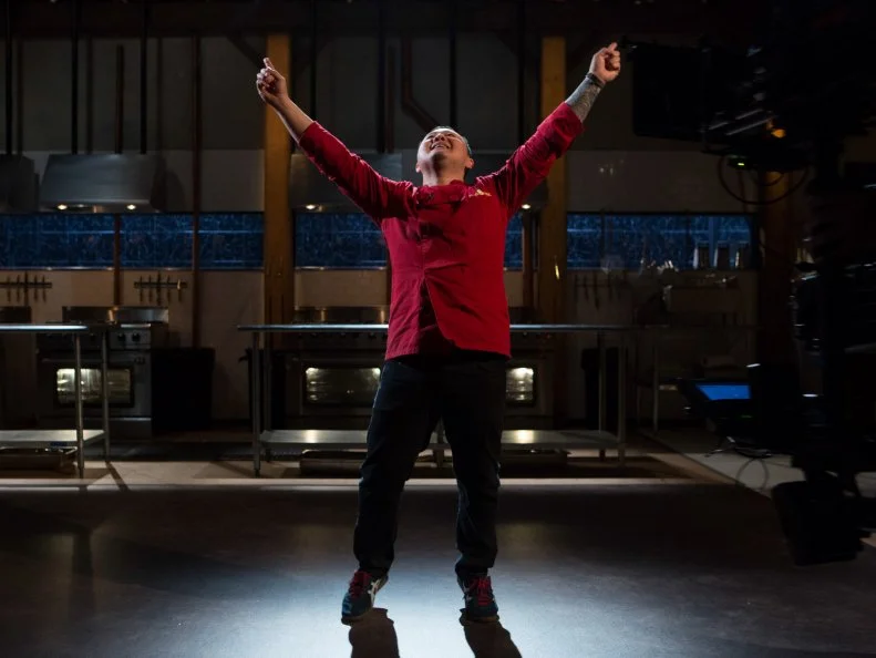 Chef Jet Tila reacts after host Ted Allen and judges: Scott Conant, Amanda Freitag and Aaron Sanchez reveal that he has secured a spot in the $75,000 charity competition for Chopped All-Stars $75,000 charity competition, as seen on Food Network's Chopped, Season 24.