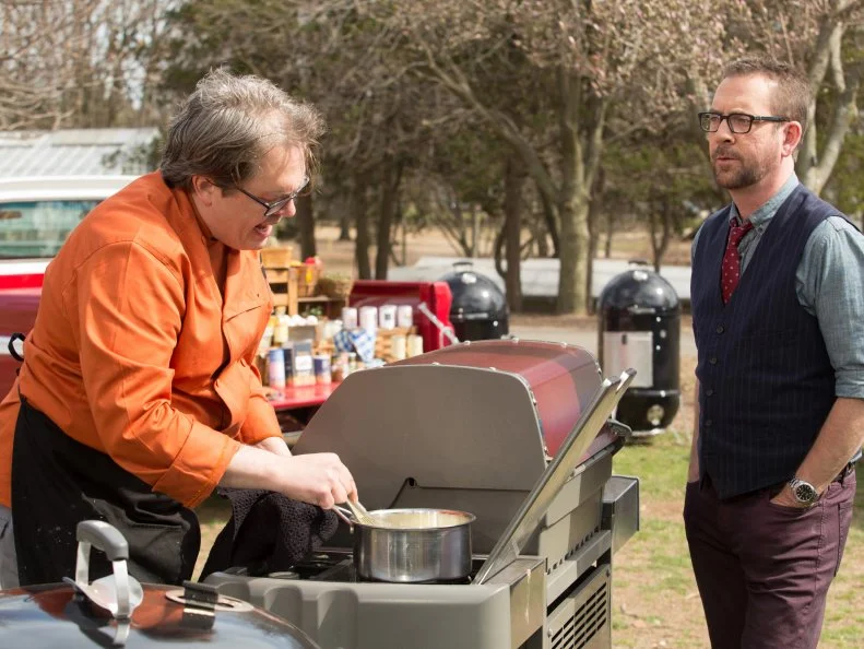 Chopped host Ted Allen checks in on chef Chris Hart as he works on his dessert the must include:  ham steaks, mangos, corn bread and ricotta cheese, as seen on Food Network's Chopped, Grill Masters Special.