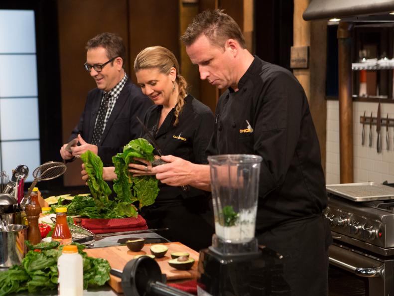 Chopped host Ted Allen helps chef Frietag open avocados while chefs Freitag and Murphy work on their dishes that must include: North Carolina style bbq sauce, pork spare ribs, rainbow chard and avacados , as seen on Food Network's Chopped After Hours, Season 23.