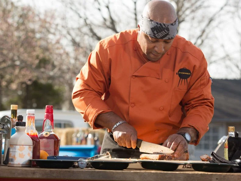 Chef Phil Johnson working on his appetizer that must include: spare ribs, rhubarb, fava beans and black eyed pea cake, as seen on Food Network's Chopped, Grill Masters Special.