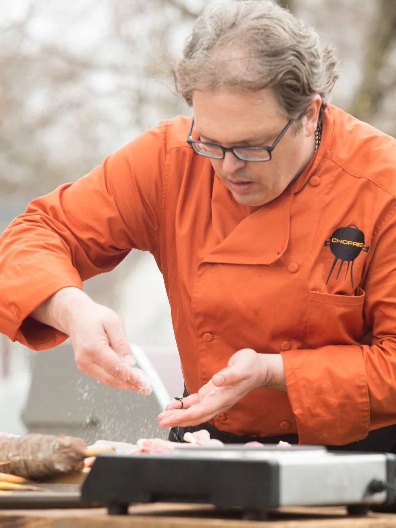 Chef Chris Hart works on his entree that must include: baby goat, rainbow carrots, watermelon and kokoretsi, as seen on Food Network's Chopped, Grill Masters Special.