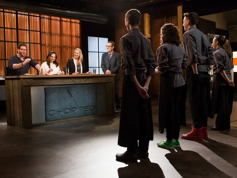 (R-L) Teens: Yazmene Kaylani (16), Theo Vicioso (17) Anna Mindell (15) and Franco Fugel (14) stand before Chopped host Ted Allen and judges: Scott Conant, Maneet Chauhan and Amanda Freitag to defend their work on their appetizers that must have included: swordfish, black garlic mayonnaise, lemon leaves and bears head mushrooms for Chopped Teen Week $25,000 tournament, as seen on Food Network's Chopped, Season 25.