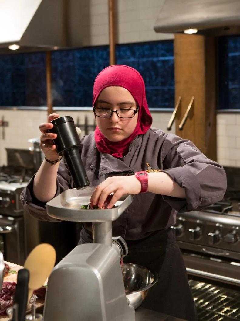 15 year old Salma Zahran works on her entree that must include: lamb shoulder, bok choy, coconut milk and dates for Chopped Teen Week $25,000 tournament, as seen on Food Network's Chopped, Season 25.