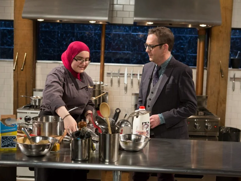 Chopped host Ted Allen checks in on 15 year old Salma Zahran works on her dessert that must include: powdered peanut butter, ice cream sandwiches, marshmallows and curry powder for Chopped Teen Week $25,000 tournament, as seen on Food Network's Chopped, Season 25.
