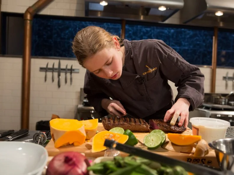 13 year old Eliza McKelvey works on her entree that must include:  venison roast, butternut squash, fruity cereal macaroons and okra for Chopped Teen Week $25,000 tournament, as seen on Food Network's Chopped, Season 25.