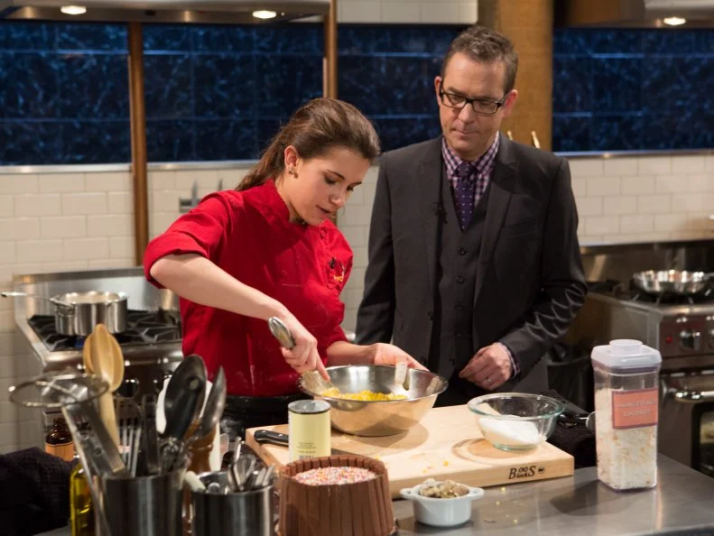 Chopped host Ted Allen checks in on Teen Chopped champion 15 year old Veronica Seguin as she works on her dessert that must include: toasted coconut chips, Shirley Temple (drink), quail eggs and a chocolate wafer cake for Chopped Teen Week $25,000 tournament, as seen on Food Network's Chopped, Season 25.