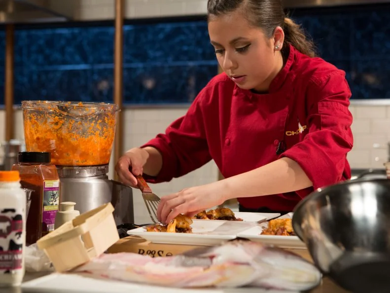 Teen Chopped champion 16 year old Yazmene Kaylani  works on her entree that must include: whole tile fish, baby planet carrots, chanterelle mushrooms and corned beef hash for Chopped Teen Week $25,000 tournament, as seen on Food Network's Chopped, Season 25.