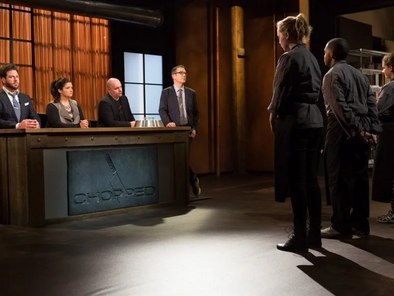 Teens: 15 year old Veronica Seguin, 16 year old Justin Ballenger and 13 year old Olivia Neumark stand before Chopped host Ted Allen and judges: Scott Conant, Alex Guarnaschelli and Chris Santos moments before finding out which teens will move on to the next round and which teen has been Chopped for Chopped Teen Week $25,000 tournament, as seen on Food Network's Chopped, Season 25.