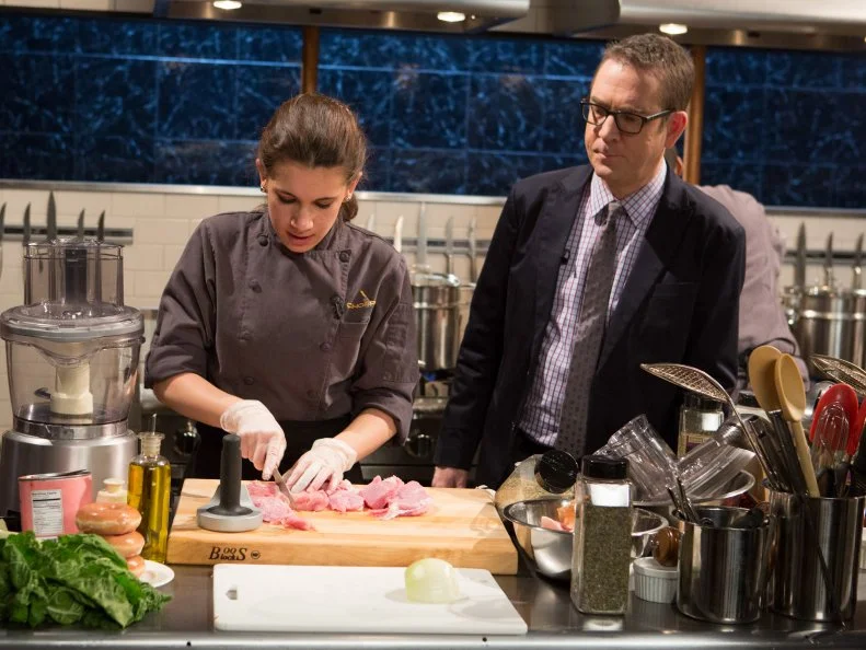 Chopped host Ted Allen checks in on 15 year old Veronica Seguin as she works on her entree that must include: veal chops, heirloom tomatoes, glazed donuts and swiss chard for Chopped Teen Week $25,000 tournament, as seen on Food Network's Chopped, Season 25.