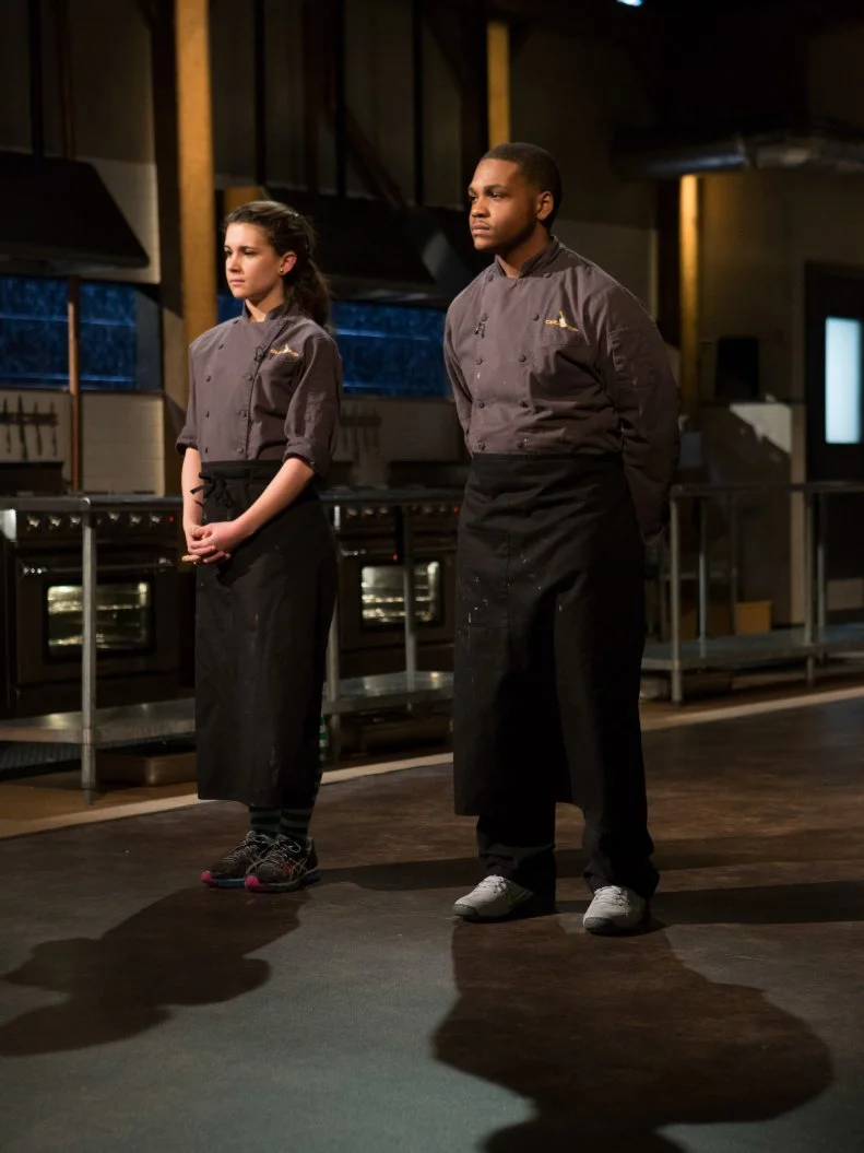 15 year old Veronica Seguin and 16 year old Justin Ballenger stand before Chopped host Ted Allen and judges: Scott Conant, Alex Guarnaschelli and Chris Santos moments before finding out which teen has been chopped and which teen has become a Chopped Champion and won the last spot in the $25000 tournament for Chopped Teen Week $25,000 tournament, as seen on Food Network's Chopped, Season 25.