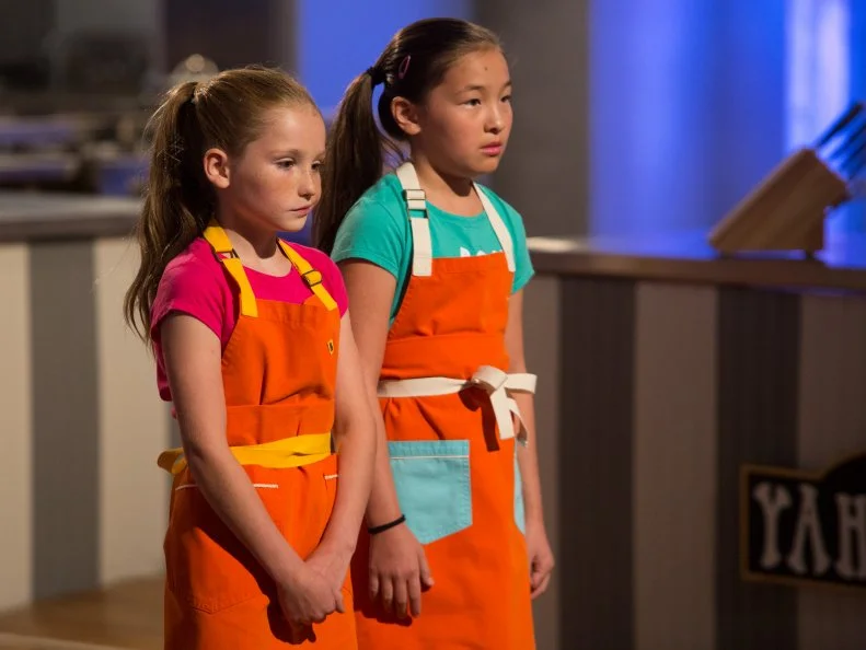 Contestants Peggy Fischer and Emma Wensing face elimination after the "Stackarons" challenge, as seen on Food Network's Kids Baking Championship, Season 2.