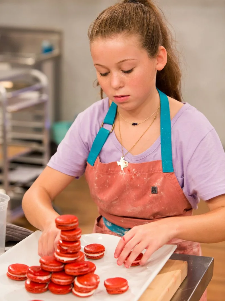 Contestant Rebecca Beale stacks her Red Velvet Macarons with strawberry cream cheese filling during the "Stackarons" challenge, as seen on Food Network's Kids Baking Championship, Season 2.
