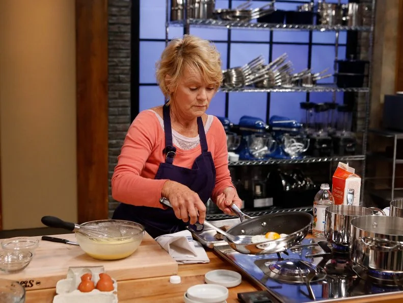 Blue team recruit Holgie Forrester prepares eggs during a skill drill challenge as seen on Food Network's Worst Cooks in America, Season 8.