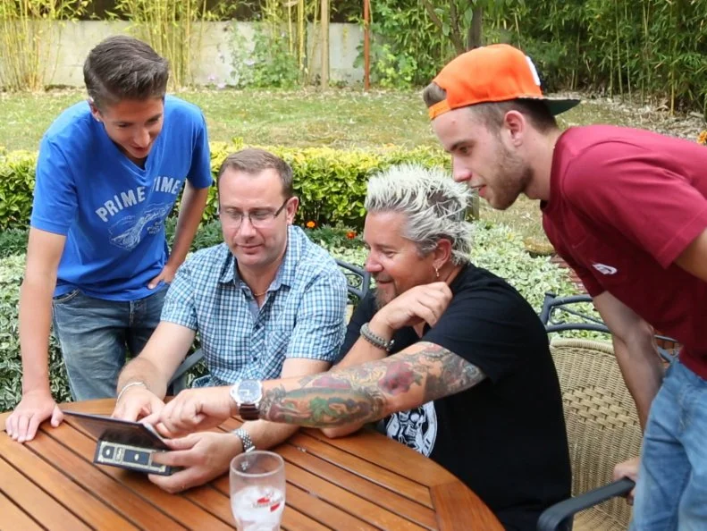 Guy and Hunter are in Chantilly, France visiting Guy's high school friend Vince Oisel where they are reminiscing and looking at old photos as seen on Food Network's Guy's European Vacation episode 4.