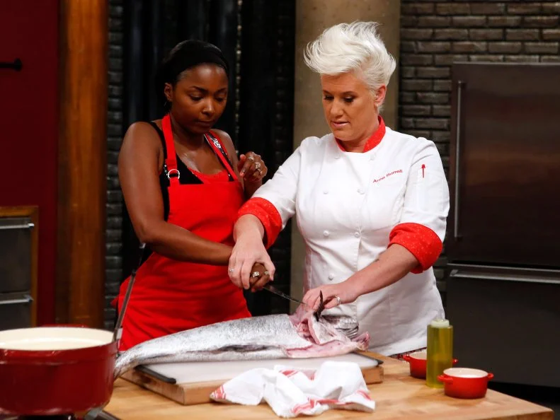 Host Anne Burrell checks in on red team recruit Chanda Havard as she prepares Fish and Chips during the elimination challenge as seen on Food Network's Worst Cooks in America, Season 8.