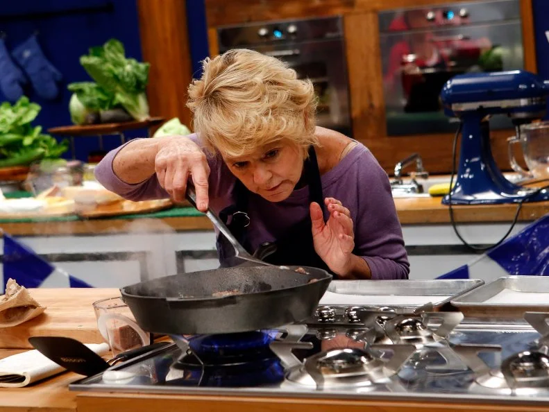 Blue team recruit Holgie Forrester cooks during the skill drill challenge as seen on Food Network's Worst Cooks in America, Season 8.