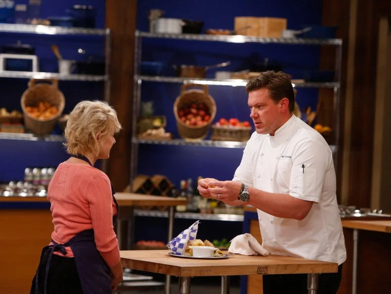 Host Tyler Florence tastes blue team recruit Holgie Forrester's Fish and Chips dish during the elimination challenge as seen on Food Network's Worst Cooks in America, Season 8.