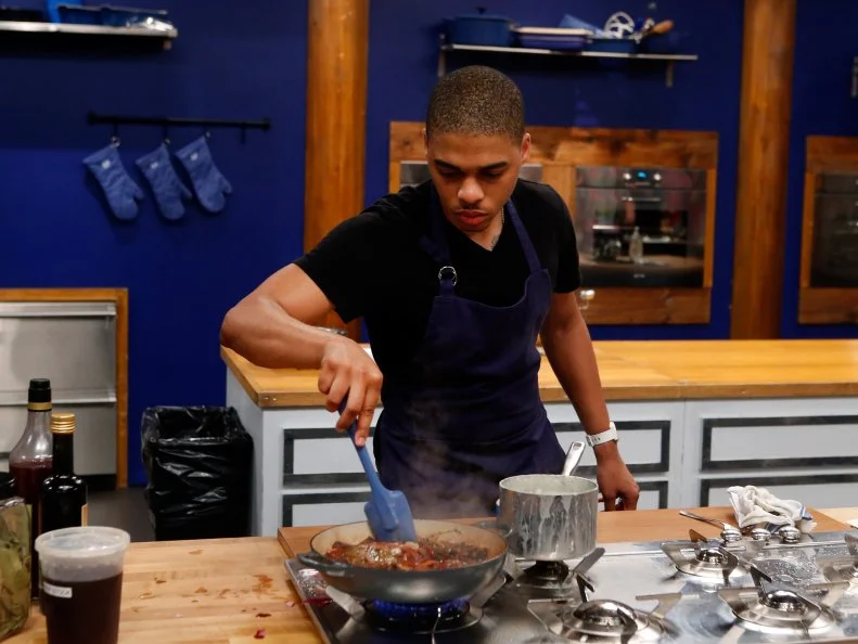 Blue team recruit Lawrence Crawford cooks Tyler Florence's Pan Seared Rib Eye with French Onion Confit and Pomme Aligot dish during the elimination challenge as seen on Food Network's Worst Cooks in America, Season 8.