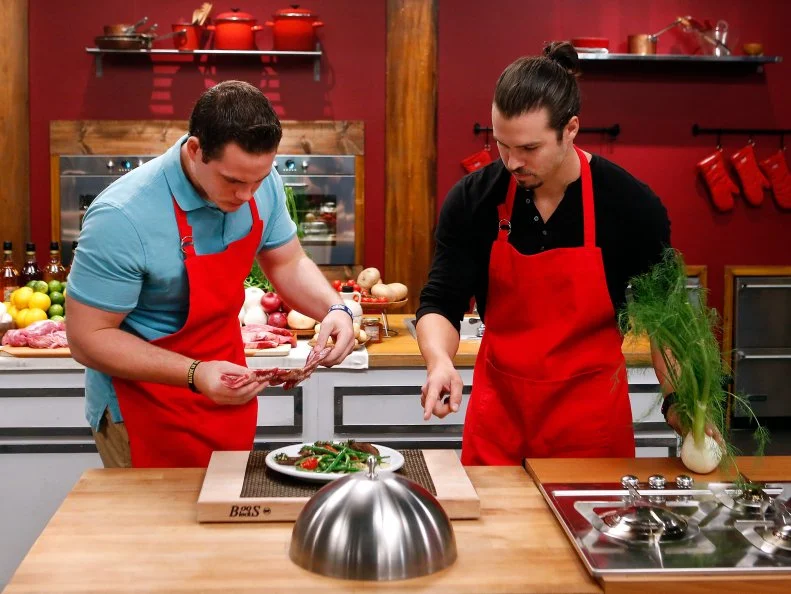 Red team recruits Taylor Hoopers, left and Nick Slater cook together during the skill drill challenge as seen on Food Network's Worst Cooks in America, Season 8.