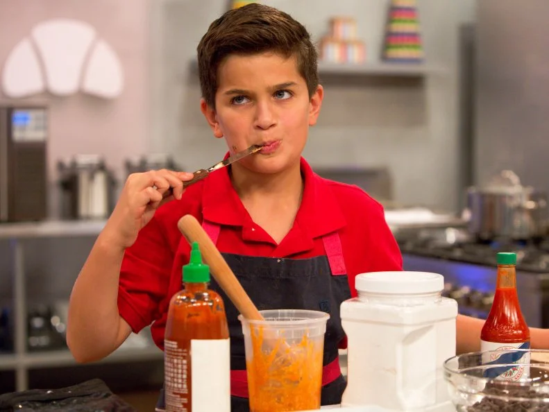Contestant Matthew Merril gives his dessert a taste test during the "Hot Chocolate" challenge, as seen on Food Network's Kids Baking Championship, Season 2.
