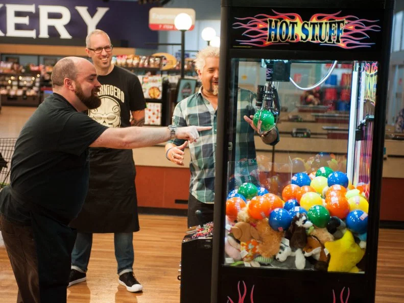 Contestant Todd Ginsberg plays "The Claw" game, as seen on Food Network's Guy’s Grocery Games, Season 8.