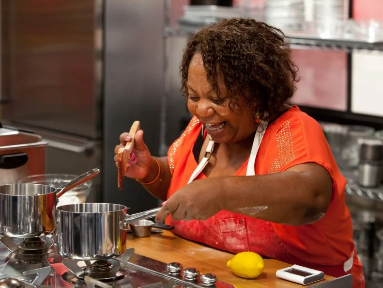 Contestant Carla Johnson works on her blueberry filling for her County Fair Donuts, as seen on Food Network's Worst Bakers In America, Season 1.