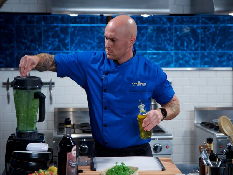 Chef Jay Abrams cooks Almond and cereal crusted lutfisk with tomato infused skordalia and a mache salad during the appetizer round, as seen on Food Network's Chopped, Season 31.