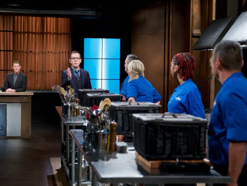 Judge Bobby Flay (L) and Host Ted Allen with chefs Cory Morris, Heather Borden, Shania Thomas, and Seis Kamimura on set, as seen on Food Network's Chopped, Season 31.