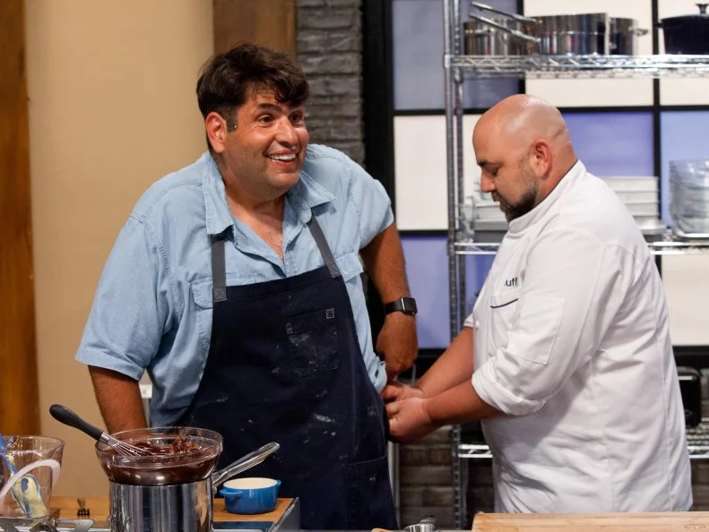 Host Duff Goldman helps contestant David Rosenberg's pants from falling down by adding a plastic wrap belt to his pants, as seen on Food Network's Worst Bakers In America, Season 1.