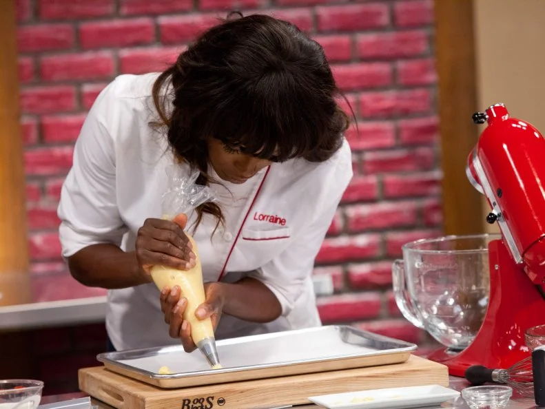 Hosts Lorraine Pascale teaches the Red and Blue Teams how to make an eclair with a Pate A Choux dough.  As seen on Food Network's Worst Bakers In America, Season 1.