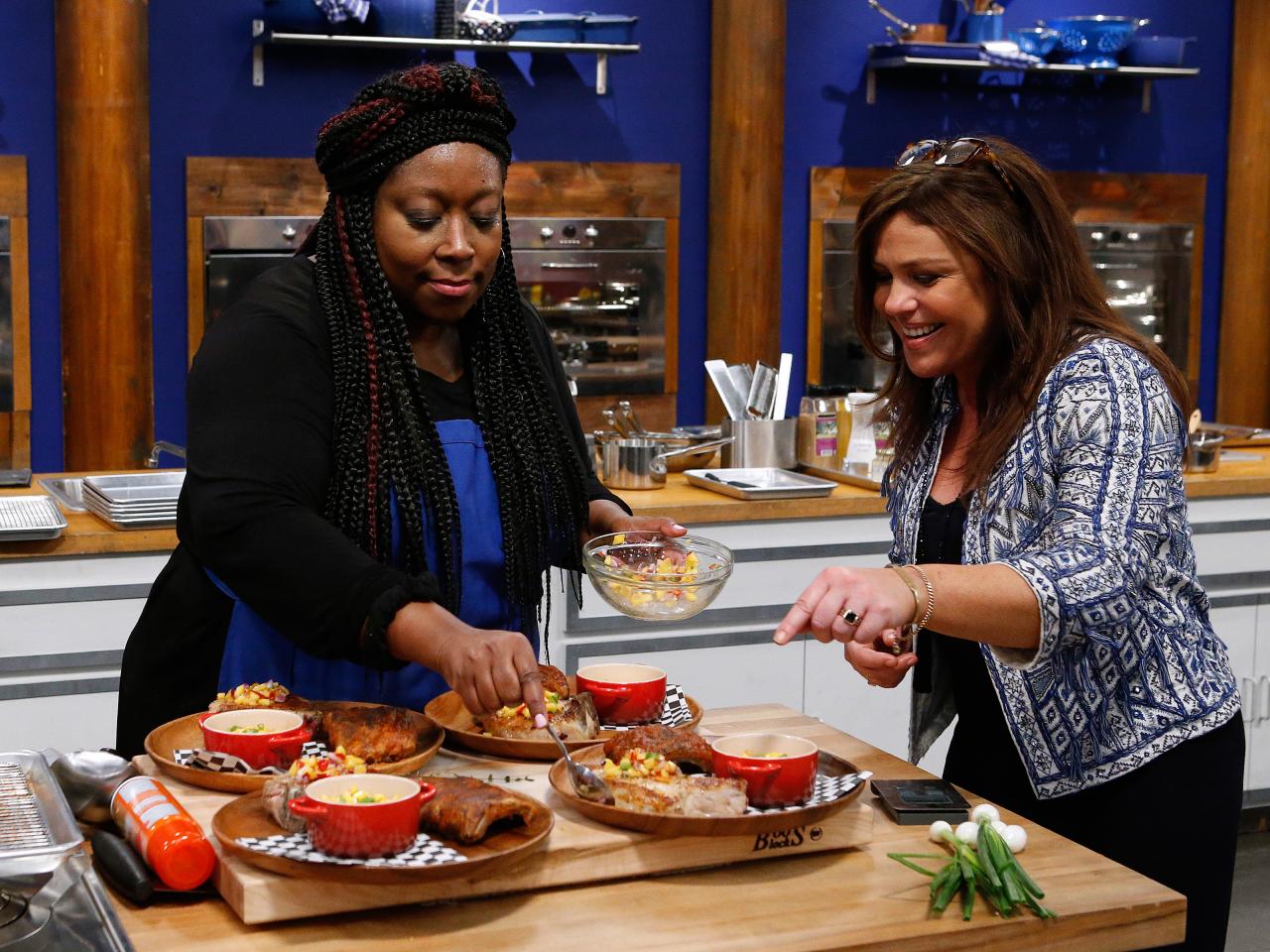 Mentor Rachael Ray watches over Loni Love of the blue team as she cooks dur...