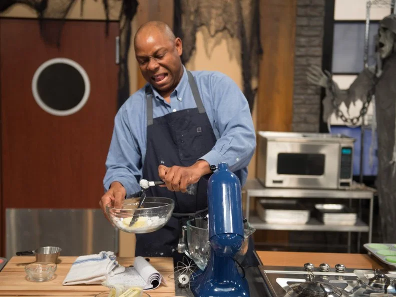 Competitor Carey Westbrook races to finish his main bake cupcake dish, as seen on Food Network’s Worst Bakers In America, Season 1.