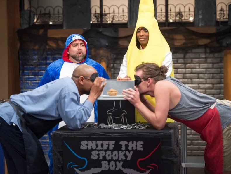 Hosts Lorraine Pascale and Duff Goldman with competitors Carey Westbrook, on left, and Jesse Wyum play a game of Sniff the Spooky Box, as seen on Food Network’s Worst Bakers In America, Season 1.