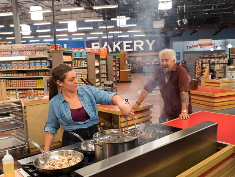 Host Guy Fieri advises contestant Samantha Mitchel, as seen on Food Network's Guy's Grocery Games, Season 11.