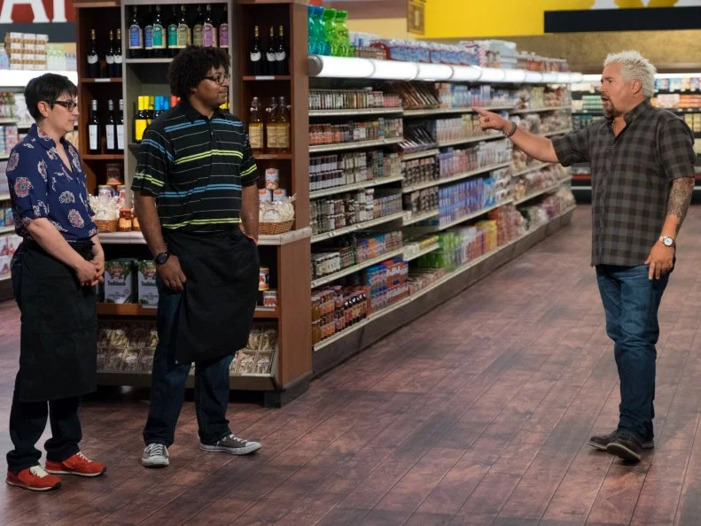 Host Guy Fieri speaks to contestants Nelle Bauer and Stephen Jones, as seen on Food Network's Guy's Grocery Games, Season 11.