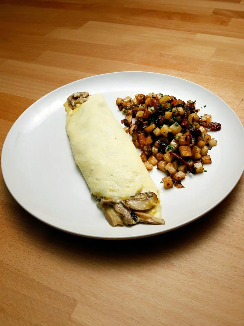 Mentor Anne Burrell's French Omelette with Mushrooms and Goat Cheese and Potato Hash with Bacon dish is displayed, as seen on Food Network's Worst Cooks in America, Season 10.